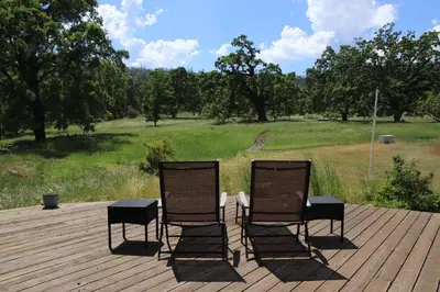 two chairs sitting on top of a wooden deck at Casa Mariposa - A Foothill Retreat near Yosemite in Mariposa
