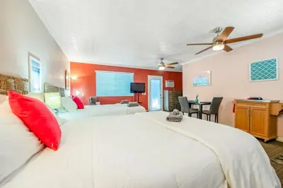 a bedroom with a large white bed with red pillows at Sequoia Studio with Private Patio in Visalia