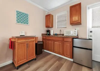 a kitchen with wooden cabinets and a white refrigerator at Sequoia Studio with Private Patio in Visalia