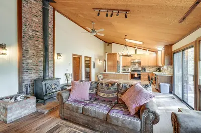 a living room with a couch and a stove at Deck and Gas Grill Secluded Arnold Cabin Rental! in Arnold