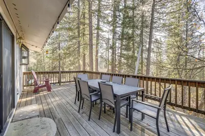 a wooden deck with a table and chairs on it at Deck and Gas Grill Secluded Arnold Cabin Rental! in Arnold