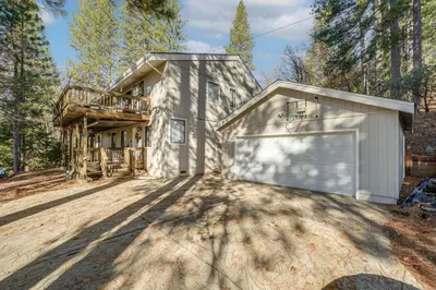 a home in the woods with a garage at Deck and Gas Grill Secluded Arnold Cabin Rental! in Arnold