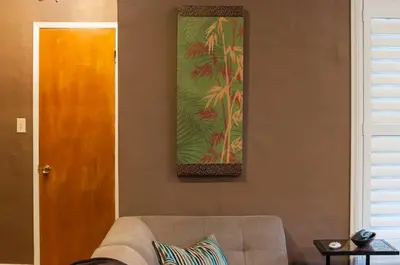 a living room with a couch and a picture on the wall at Group Retreat with Hot Tub & Studio in Visalia