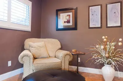 a living room with a chair and a table at Group Retreat with Hot Tub & Studio in Visalia