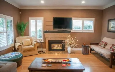 a living room with a fireplace and a flat screen tv at Group Retreat with Hot Tub & Studio in Visalia