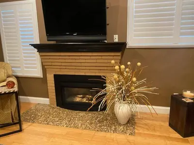 a living room with a fireplace with a tv above it at Group Retreat with Hot Tub & Studio in Visalia