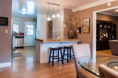 a kitchen and living room with a bar and stools at Group Retreat with Hot Tub & Studio in Visalia