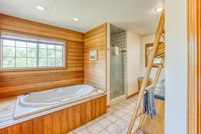 a bathroom with a tub and a window and a ladder at 11 Acre Mountain Spirit Retreat in North Fork