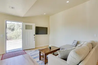 a living room with a couch and a table at Comfy Oakhurst Duplex Near Hiking and Sightseeing! in Oakhurst