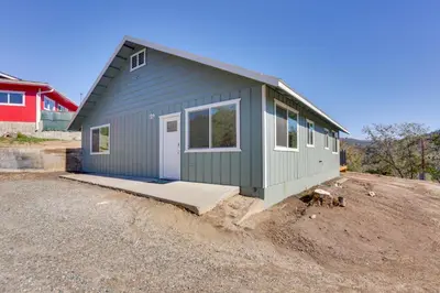 a small green house on a dirt lot at Comfy Oakhurst Duplex Near Hiking and Sightseeing! in Oakhurst