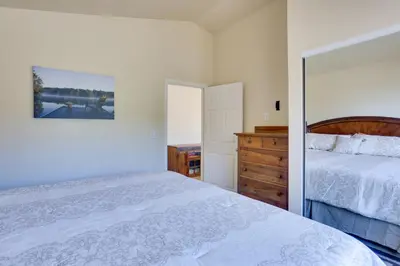 a white bedroom with a bed and a dresser at Comfy Oakhurst Duplex Near Hiking and Sightseeing! in Oakhurst