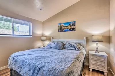 a bedroom with a bed and two lamps and a window at Oakhurst Duplex about 13 Mi to Yosemite National Park! in Oakhurst