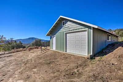 a building with a garage on top of a dirt field at Oakhurst Duplex about 13 Mi to Yosemite National Park! in Oakhurst