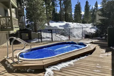 a hot tub sitting on a deck in the snow at Crestview 70 in Mammoth Lakes