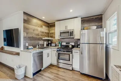 a kitchen with white cabinets and a stainless steel refrigerator at Manzanita Holiday in South Lake Tahoe