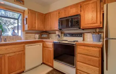 a kitchen with wooden cabinets and a stove top oven at Robins Nest- Lake Area Free Night Special in Bass Lake