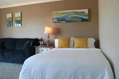 a bedroom with a white bed and a blue couch at Bellanca in Discovery Bay