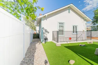 a white house with a fence and a yard at Urban Haven in Reno: Charming Studio Retreat in Reno