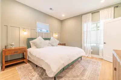 a bedroom with a bed and a table and windows at Reno Dream Cottage: Delightful 2-Bedroom Sanctuary in Reno
