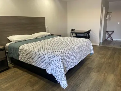 a bedroom with a bed and a table with a chair at Town House Motel in Sanger