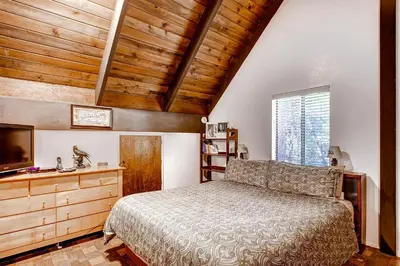 a bedroom with a bed and a wooden ceiling at Yosemite's Creekside Birdhouse in Wawona