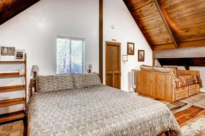 a bedroom with a large bed and a window at Yosemite's Creekside Birdhouse in Wawona