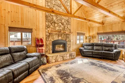 a living room with leather furniture and a stone fireplace at Black Bear Hideaway in South Lake Tahoe