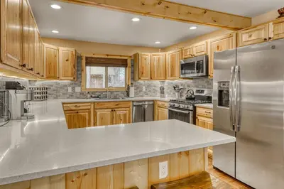 a kitchen with wooden cabinets and stainless steel appliances at Black Bear Hideaway in South Lake Tahoe