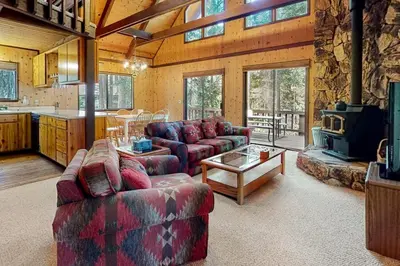 a living room with two couches and a stove at Cresta Cabin in Arnold