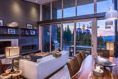 a living room with a couch and a large window at Modern Ski In-Out Home, Mid-Mountain in Truckee