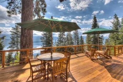 a wooden deck with a table and chairs and umbrellas at Crystal Bay Lakeview in Crystal Bay