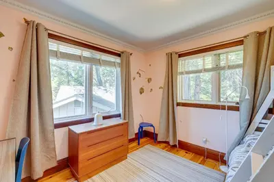 a bedroom with a bunk bed and two windows at Meadow Vista Mountain Escape with River Views! in Meadow Vista