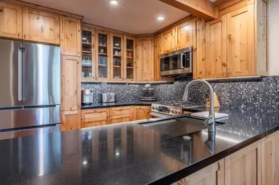 a kitchen with wooden cabinets and a stainless steel refrigerator at Updated 2 Bedroom Plus Loft 3 Bathroom Snowcreek Phase V #860 Sleeps 6 in Mammoth Lakes