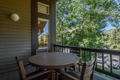 a wooden table and chairs on the porch of a house at Updated 2 Bedroom Plus Loft 3 Bathroom Snowcreek Phase V #860 Sleeps 6 in Mammoth Lakes