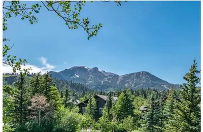 a cabin in the woods with mountains in the background at Updated 2 Bedroom Plus Loft 3 Bathroom Snowcreek Phase V #860 Sleeps 6 in Mammoth Lakes