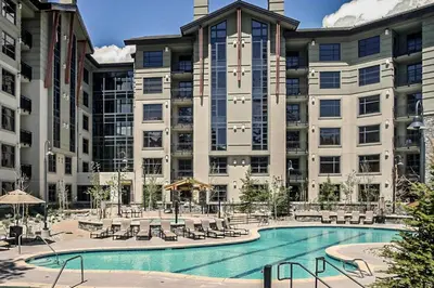 a large building with a swimming pool in front of it at Village Monache #720 condo in Mammoth Lakes