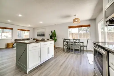 a kitchen with white cabinets and a dining room at half Mi to Lake Tahoe Pet-Friendly Cabin in South Lake Tahoe