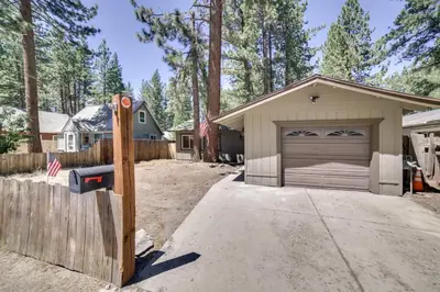 a house with a parking meter in front of a garage at half Mi to Lake Tahoe Pet-Friendly Cabin in South Lake Tahoe
