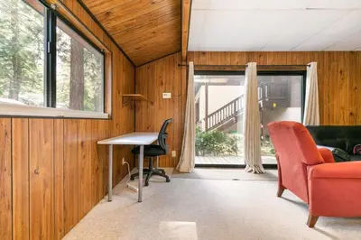 a living room with a red chair and a desk and a window at Agate Bay 3BDR, Walking Distance to the Beach! in Tahoe Vista
