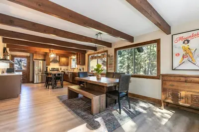 a kitchen and living room with a wooden table at Brand New 3BDR Cabin 4 Min to Ski Resort and Beach in Tahoma
