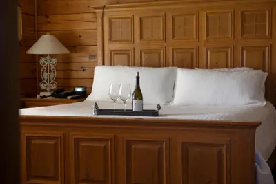 a bed with a bottle of wine and two glasses at Purple Orchid Resort & Spa in Livermore