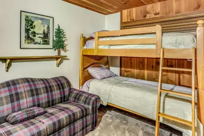 a living room with a couch and a bunk bed at 3 Mi to Shaver Lake Cozy Bears Hideaway Cabin! in Shaver Lake