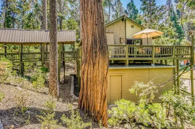 a house with a deck and a tree at 3 Mi to Shaver Lake Cozy Bears Hideaway Cabin! in Shaver Lake