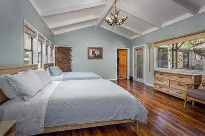 a bedroom with a large white bed and a dresser at Magical River House ! 10 min to SNP park entrance in Three Rivers