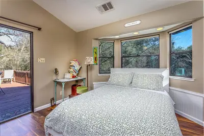 a bedroom with a bed and two windows at Magical River House ! 10 min to SNP park entrance in Three Rivers