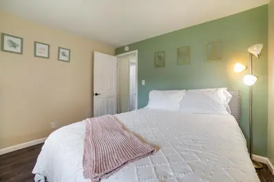 a bedroom with a white bed with a pink blanket on it at Pet-Friendly Home with Hot Tub! 6 Mi to Dtwn Reno in Reno