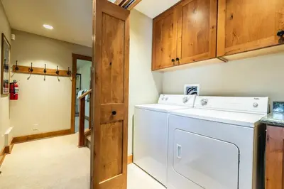 a washer and dryer in a kitchen with wooden cabinets at EJ's Point Walk to Beach in Tahoe City
