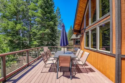 a deck with a table and chairs and an umbrella at EJ's Point Walk to Beach in Tahoe City