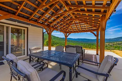 a patio with a table and chairs and a pergola at Hidden Falls Retreat Peaceful Guesthouse Near Yosemite in Oakhurst