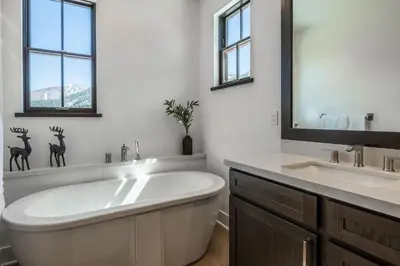 a white bathroom with a tub and a sink at Creekhouse 1342 in Mammoth Lakes